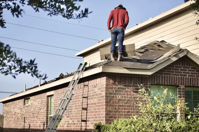 Professional roofer working on a residential roof in The Cloisters at Charles